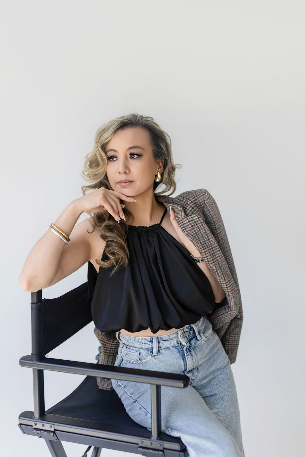 Tramy Nguyen, founder of Envision, seated in a director's chair
