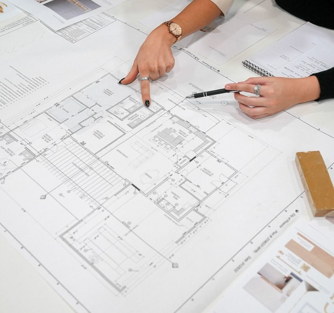 Team reviewing architectural floor plans and material samples on a table